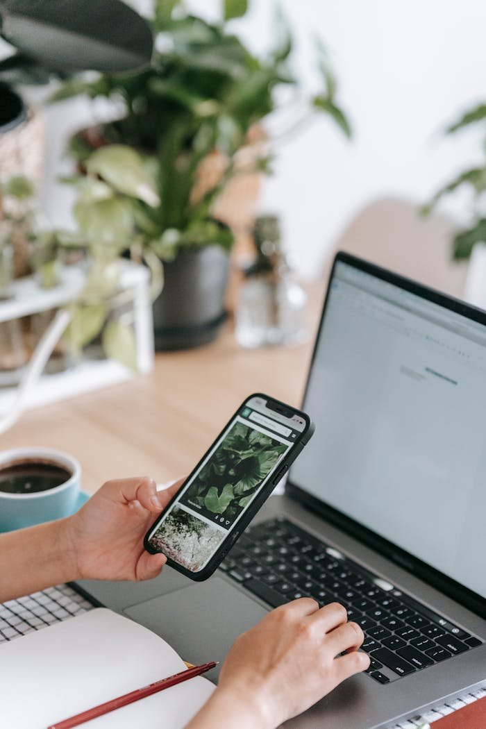 Crafting Captivating Headlines: Your awesome post title goes here Crop unrecognizable person working on netbook and browsing mobile phone while sitting at desk with copybook and cup of coffee in light room